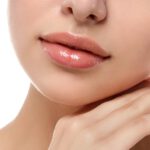 Close up view of young beautiful caucasian woman touching her face isolated over white background. Lips contouring, SPA therapy, skincare, cosmetology and plastic surgery concept